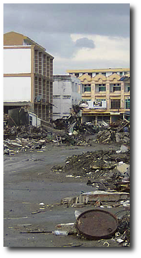 She’d huddled at the top of the building for weeks, scavenging food from the vending machines and crying for her father, but no one came back. No one but the ghosts. Artwork : This photo of Banda Aceh is in the public domain and comes to us courtesy of . 
