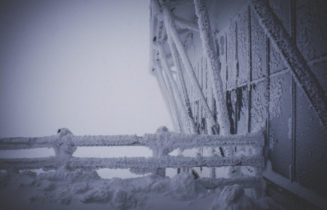 Ice and snow on a barn door and fence